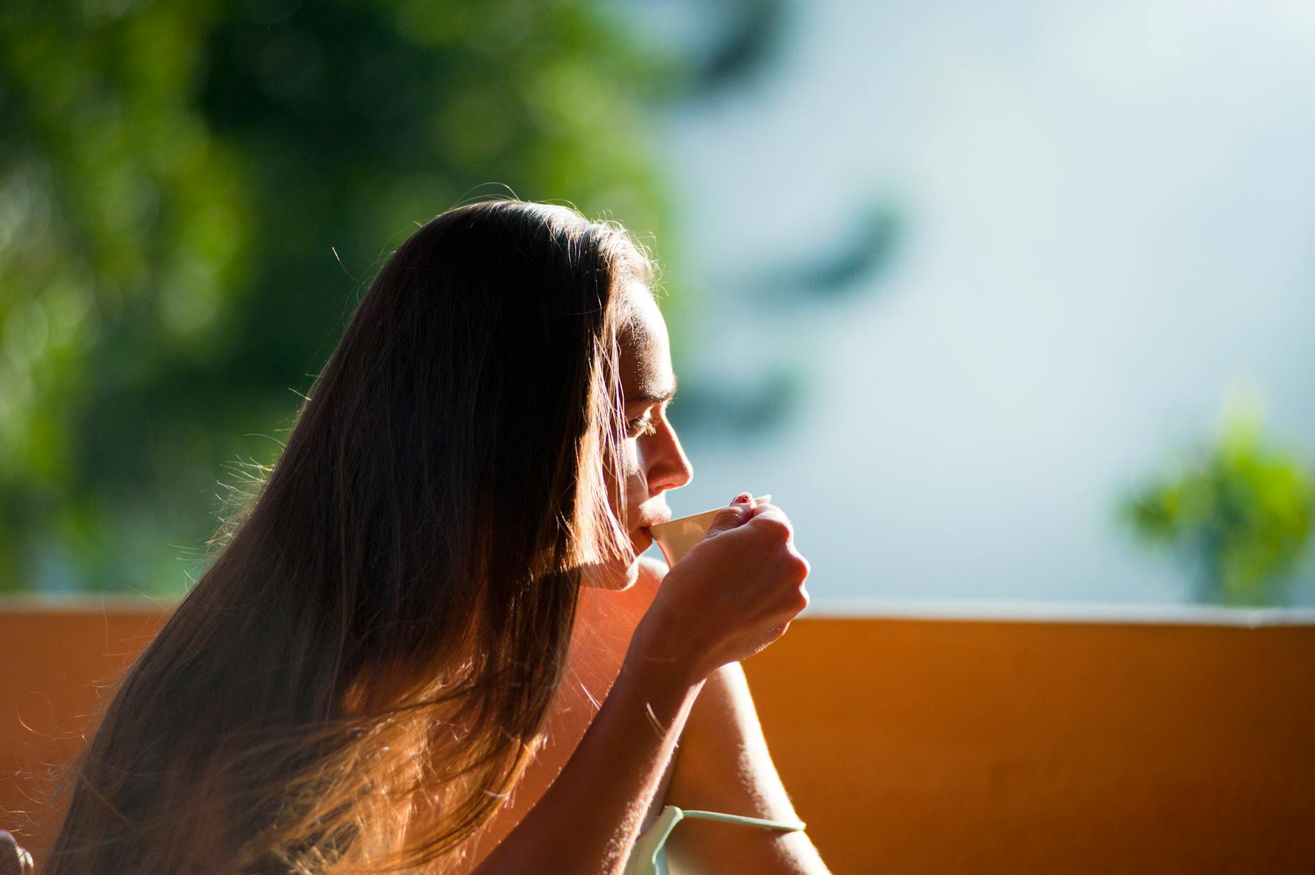 Person enjoying a morning cup of tea in sunlight