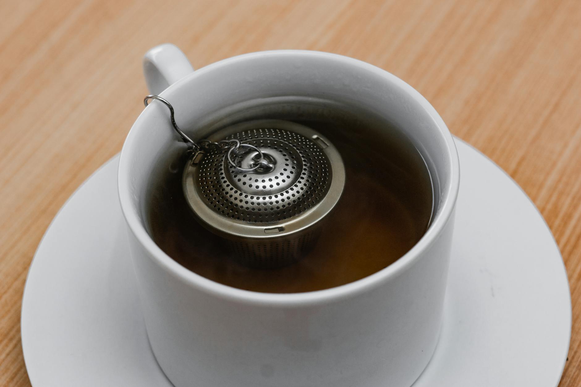 Black tea steeping in hot water, releasing color and caffeine
