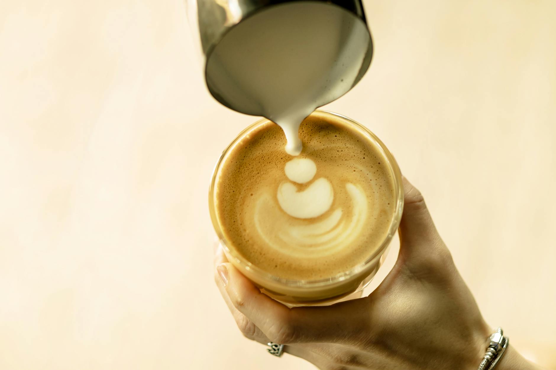 Steamed milk being poured into a chai latte, showing the final result of both powder and concentrate preparations