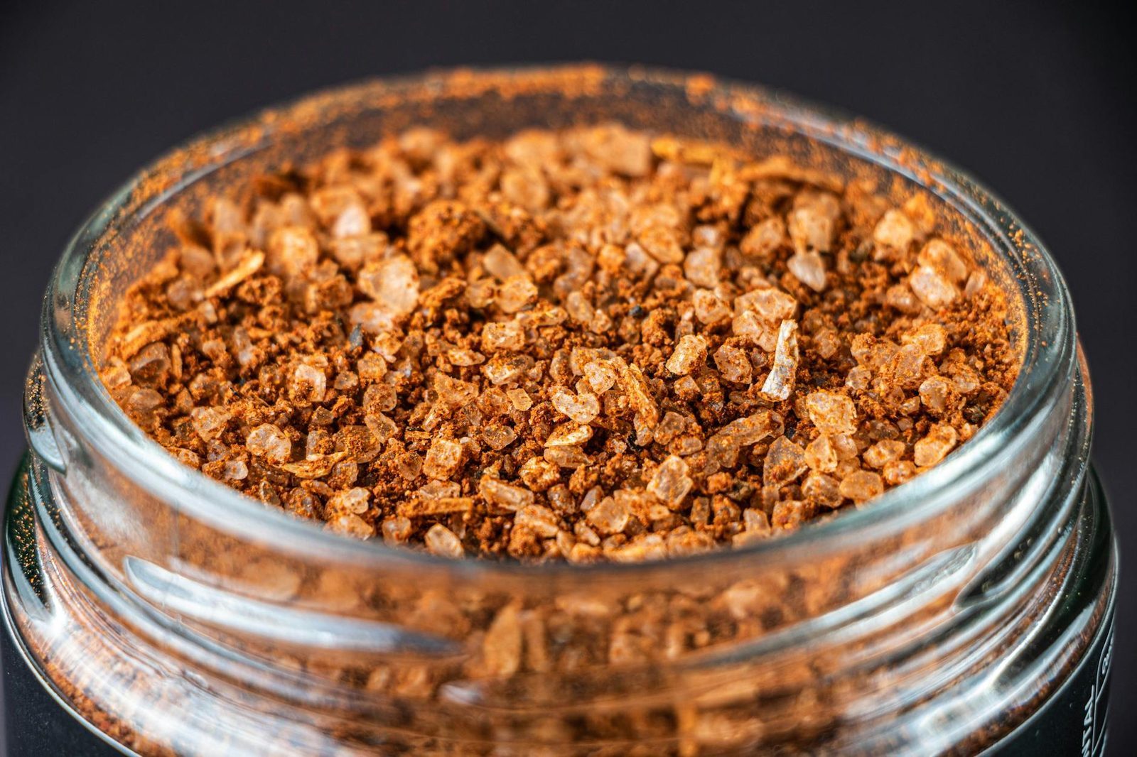 Macro shot of artisan spice blend in a glass jar, showing quality ingredients