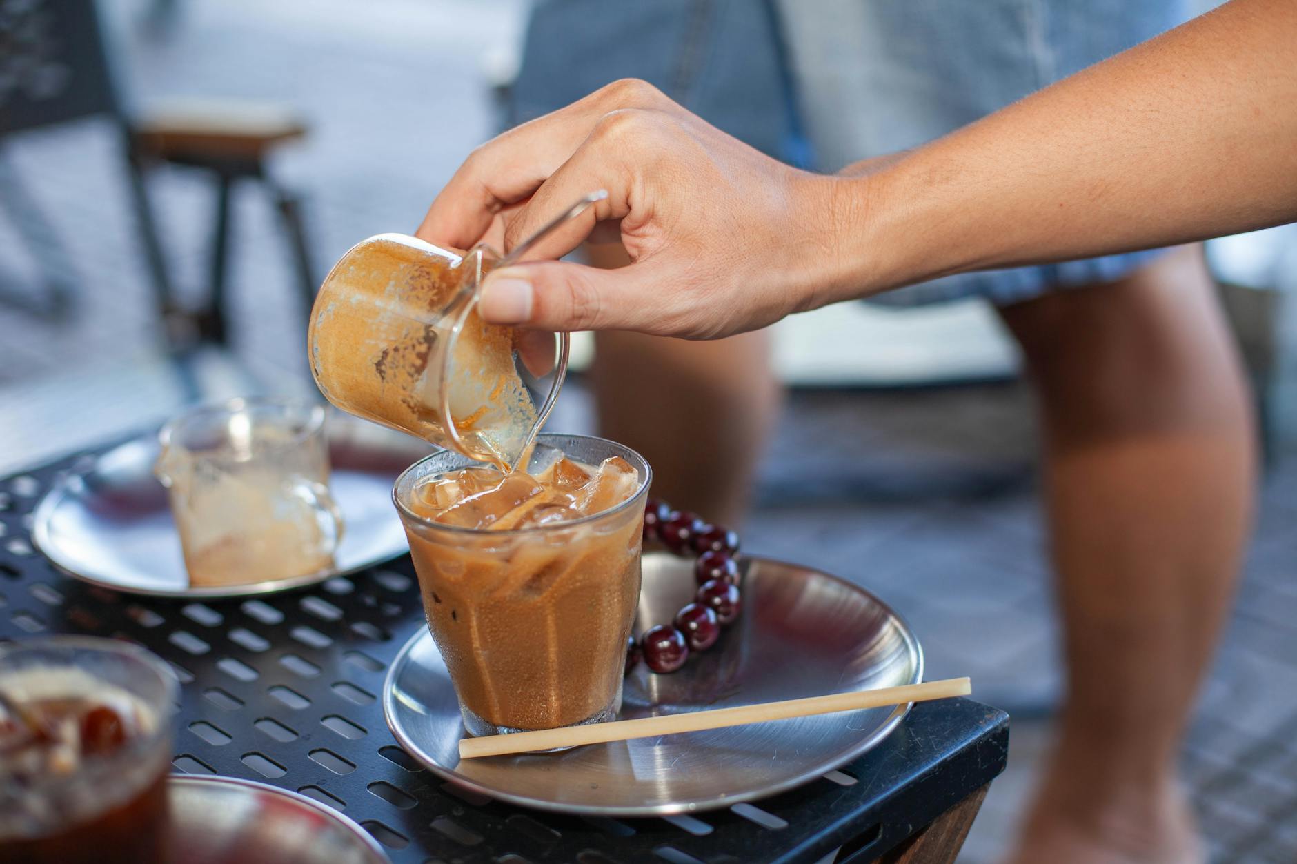 Cold chai being poured over ice into a glass