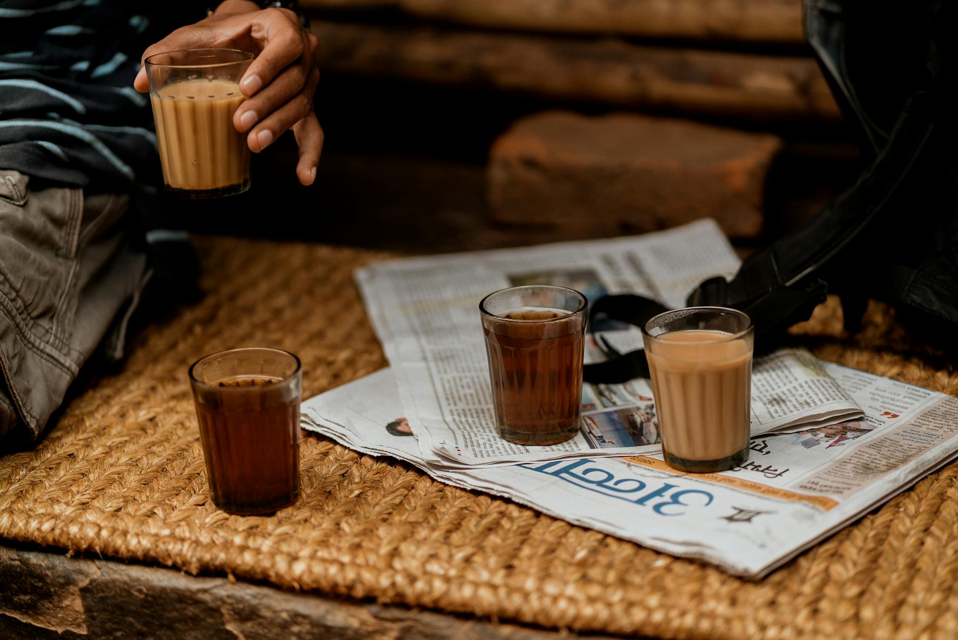 Traditional glasses of Nepali milk tea on a woven rug, a naturally low-carb chai preparation