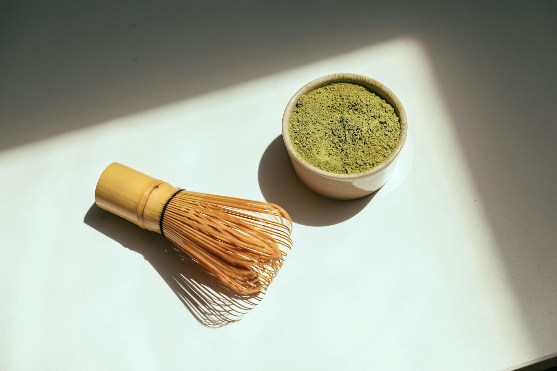 Bright green matcha powder in a traditional bowl