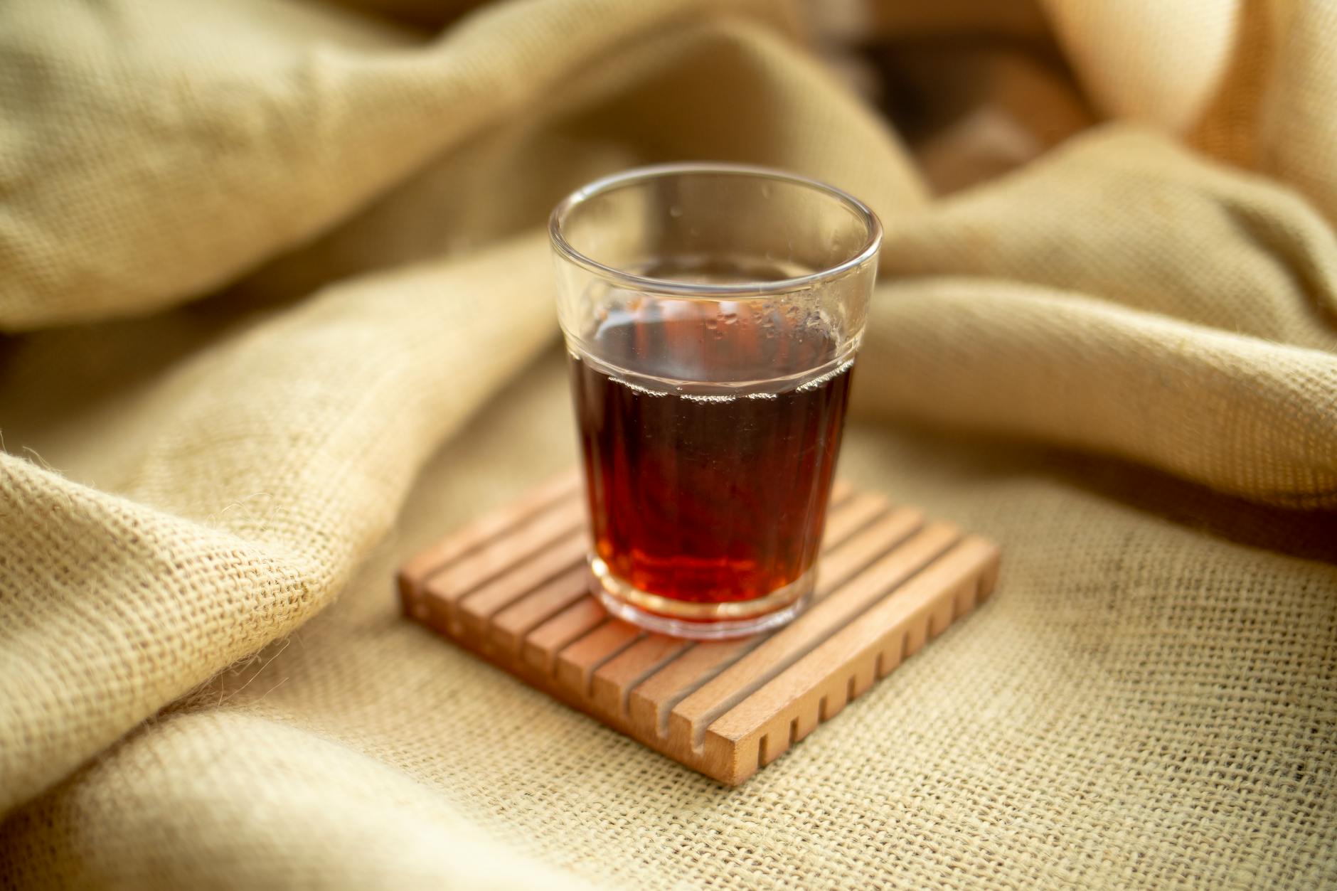 Glass of sugar-free chai tea on natural burlap cloth