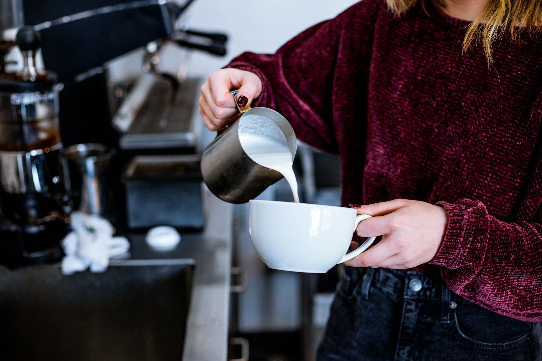Barista steaming milk for a chai latte